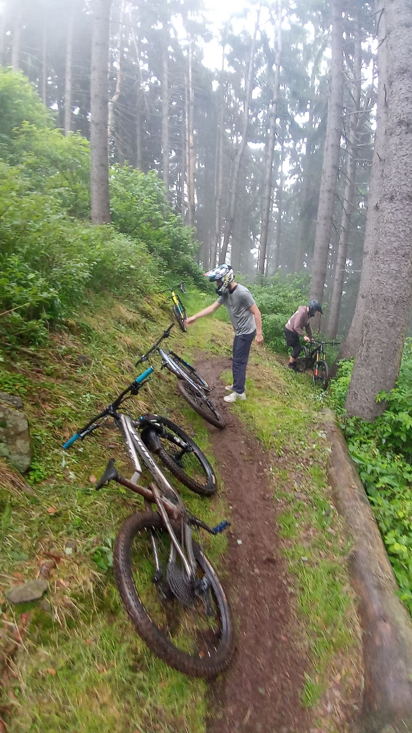 Riderzy podchodzą z rowerami pod trasę we mgle